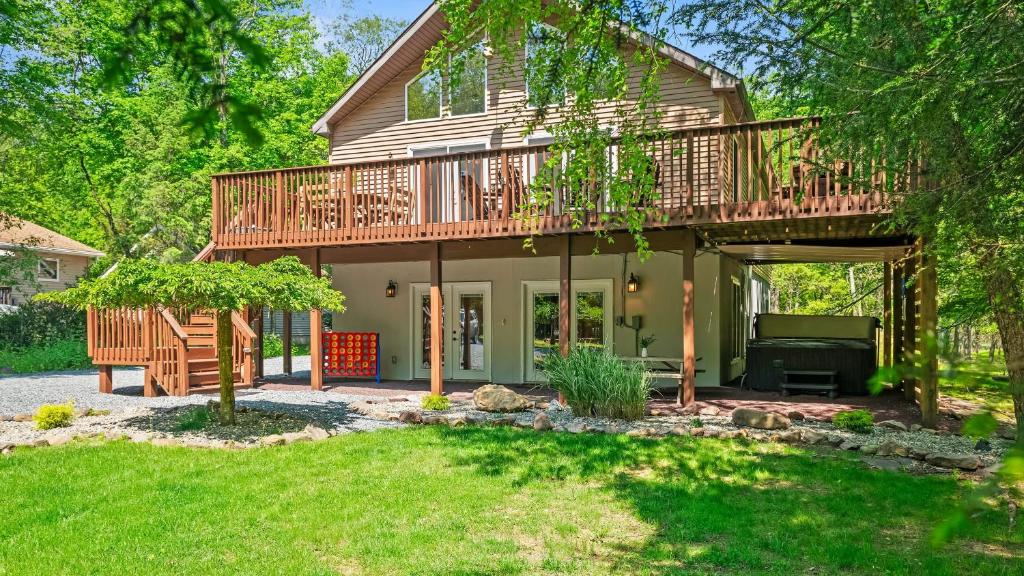 a large house with a deck and a yard at Mews Mountain House by AvantStay Walk to Beach Hot Tub Game Room in Albrightsville