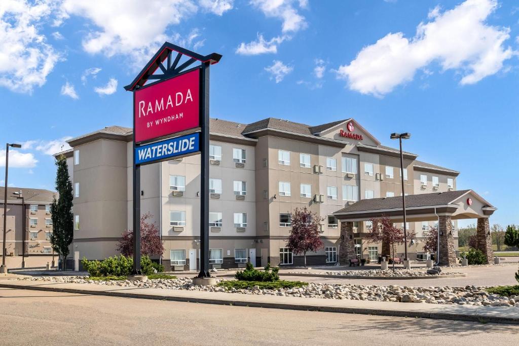 a hotel with a sign in front of a building at Ramada by Wyndham Lac La Biche in Lac La Biche