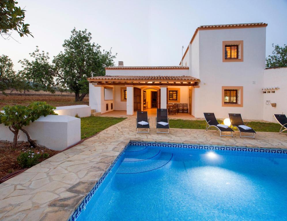 a villa with a swimming pool in front of a house at Can Cama in Santa Gertrudis de Fruitera