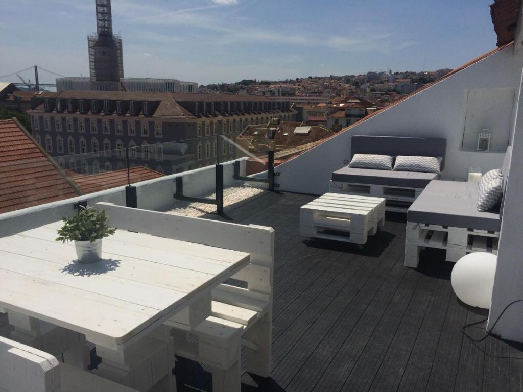 a balcony with a table and benches on a roof at A Terrace on a Topfloor with a View in Lisbon