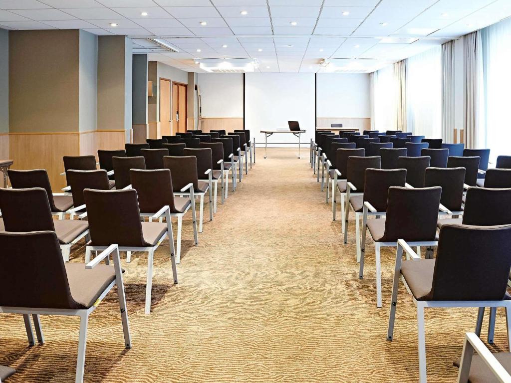 a room with rows of chairs in a classroom at Novotel Leeds Centre in Leeds