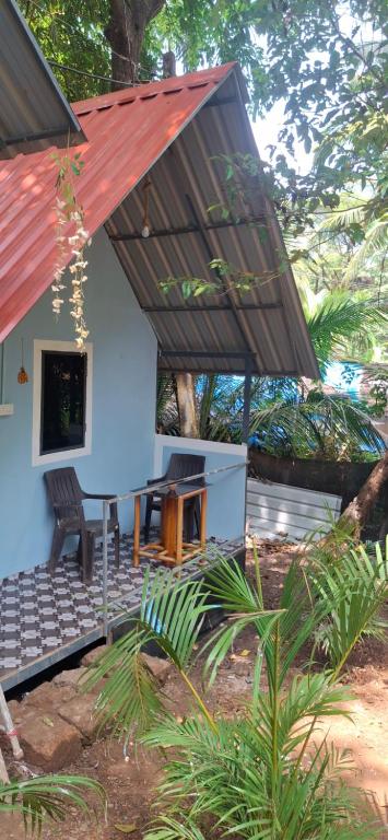 a house with a red roof and a picnic table at green Garden Resort in Canacona