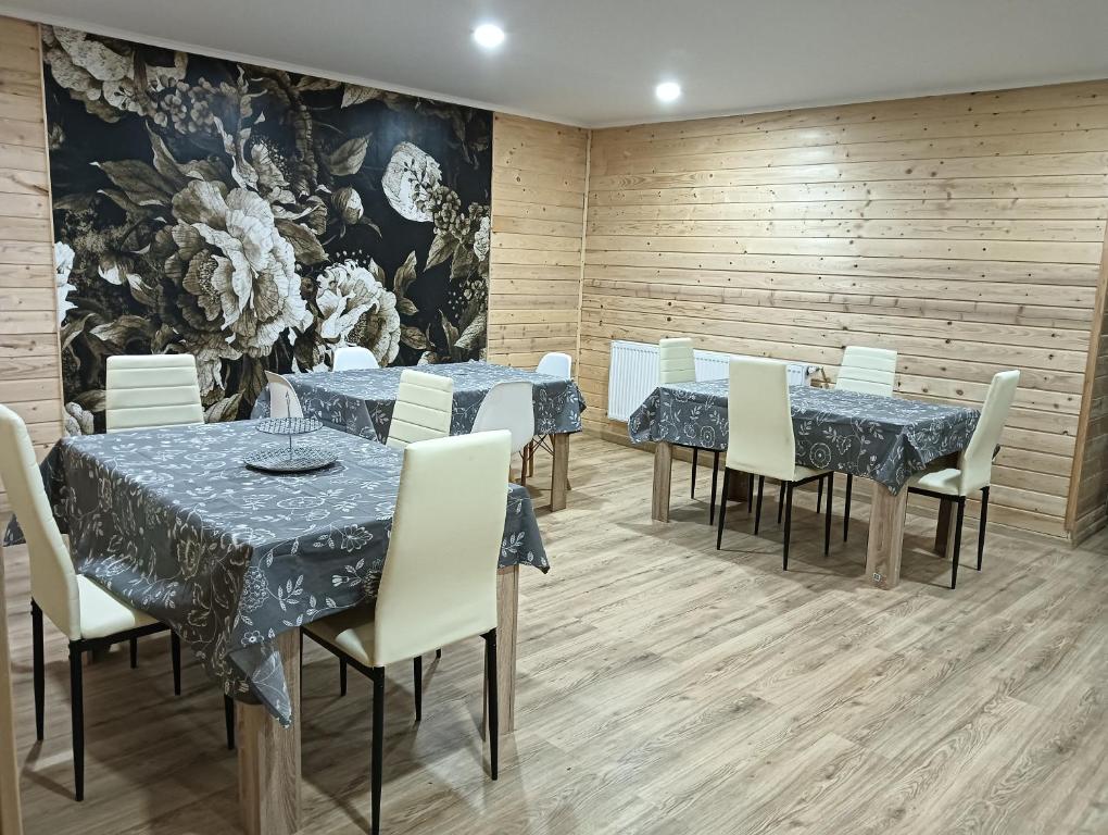 a dining room with blue tables and white chairs at Casuta D&M in Cisnădie