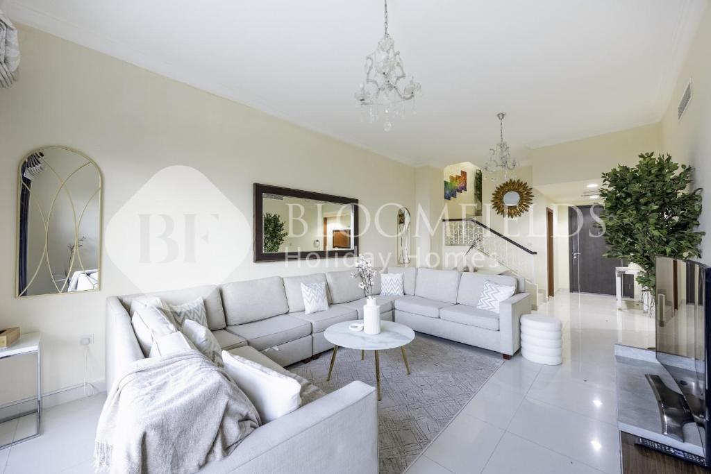 a living room with a white couch and a table at Bloomfields Lux 2BR Plus Maid wz Beach Access & Sea View Fujairah in Rūl Ḑadnā
