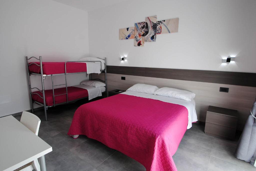 una camera con un letto con una coperta rossa di Novo Motel a Tortoreto