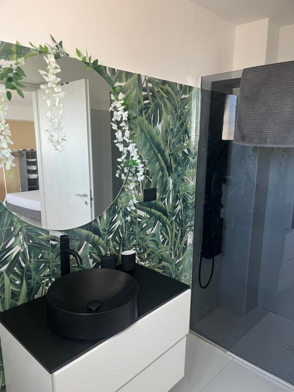 a bathroom with a black sink and a mirror at Zia Lisa Home in CTA