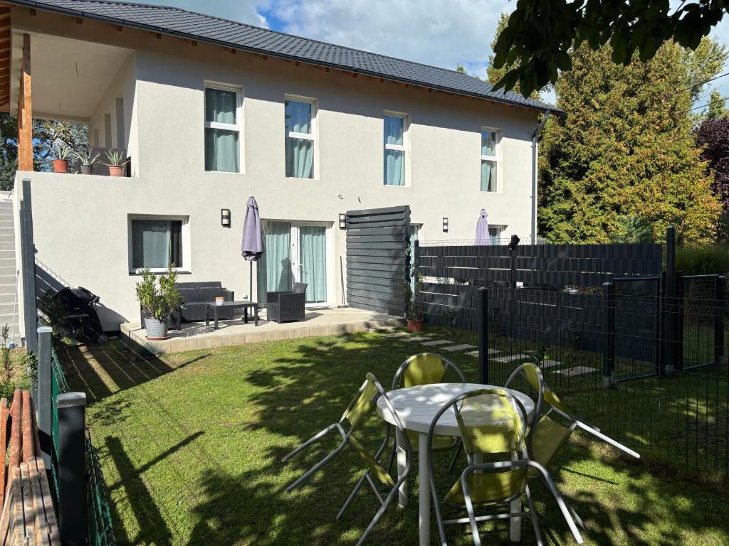 a table and chairs in the yard of a house at Marton Apartman in Balatonszemes