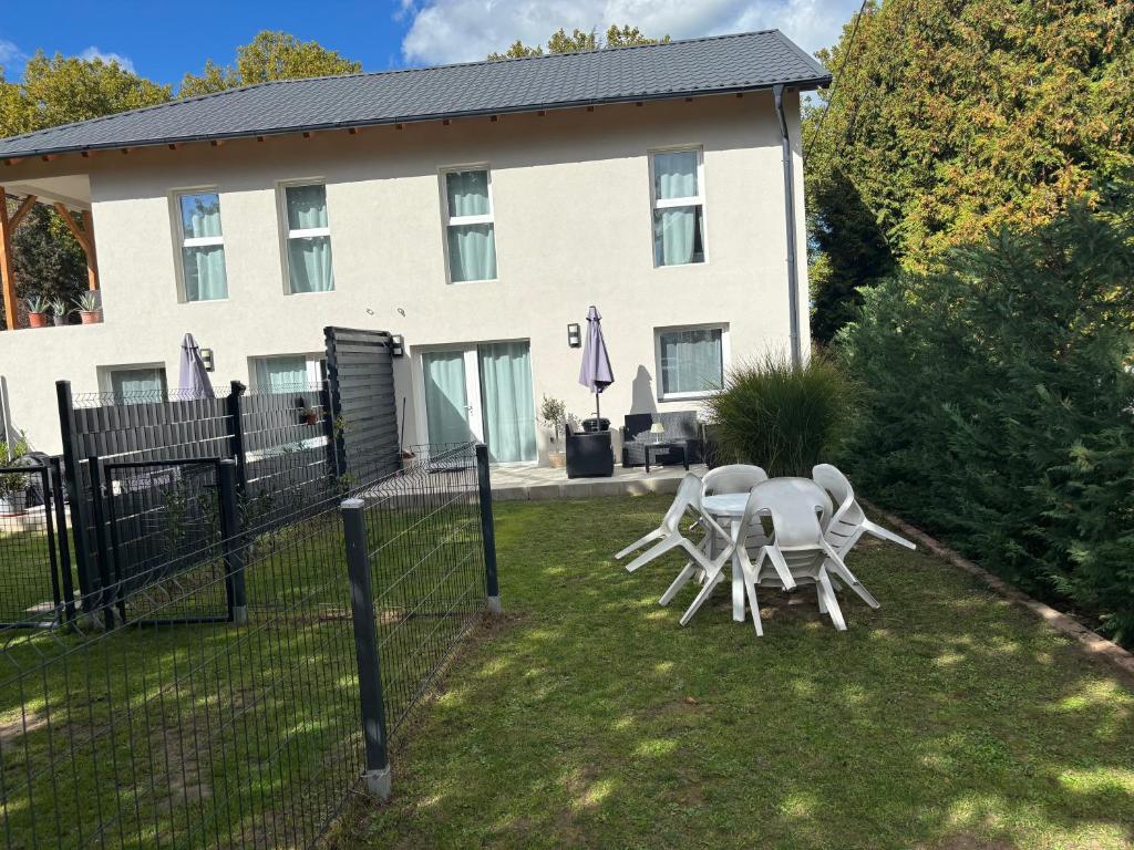 two chairs and a table in front of a house at B2 Apartman in Balatonszemes