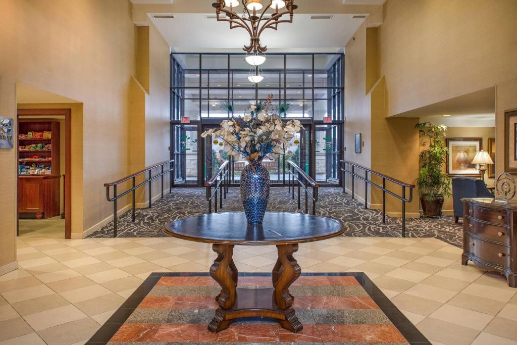 a vase with flowers on a table in a hallway at Clarion Collection Hotel Arlington Court Suites in Arlington