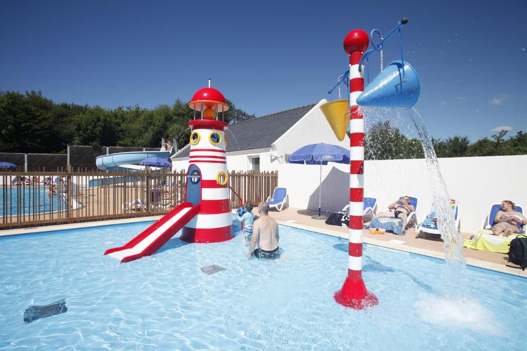 - un groupe de personnes dans une piscine avec toboggan dans l'établissement Domaine Résidentiel de Plein Air Odalys Kerarno, à Saint-Philibert