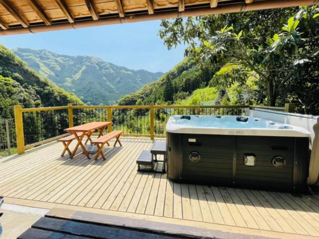 una terraza con bañera de hidromasaje y mesa de picnic en ハイランドビュー, 