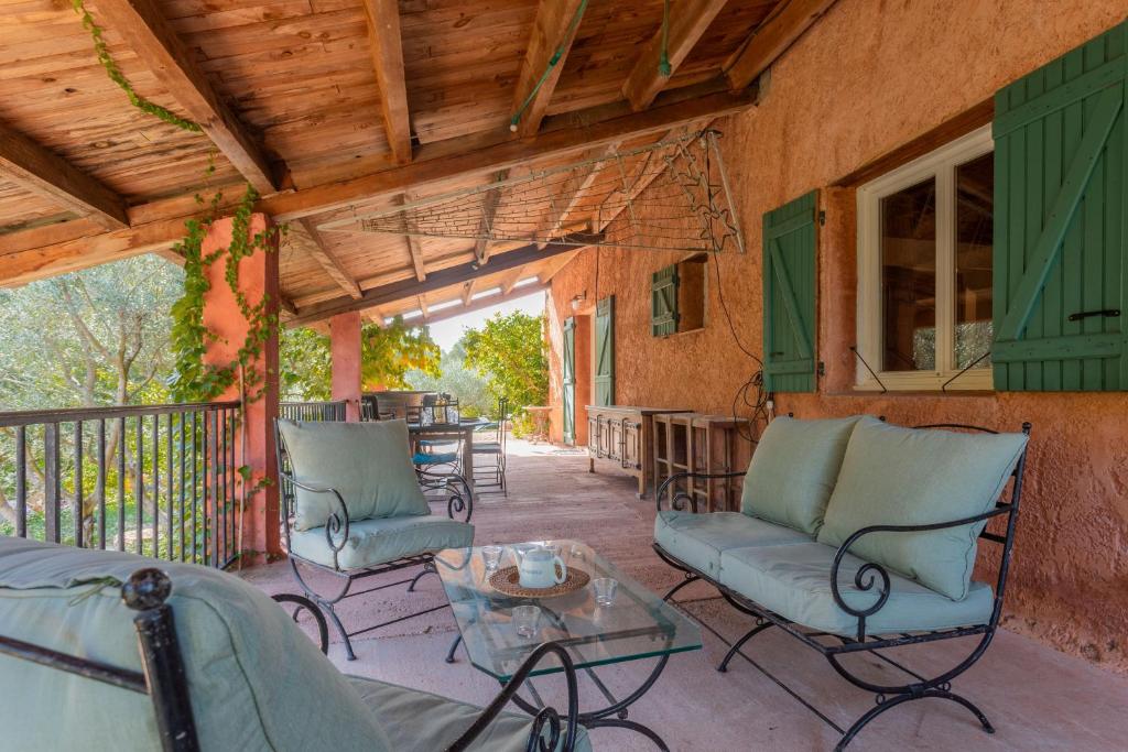 a porch with chairs and a table and a table at Gite Baba in Puget-Ville