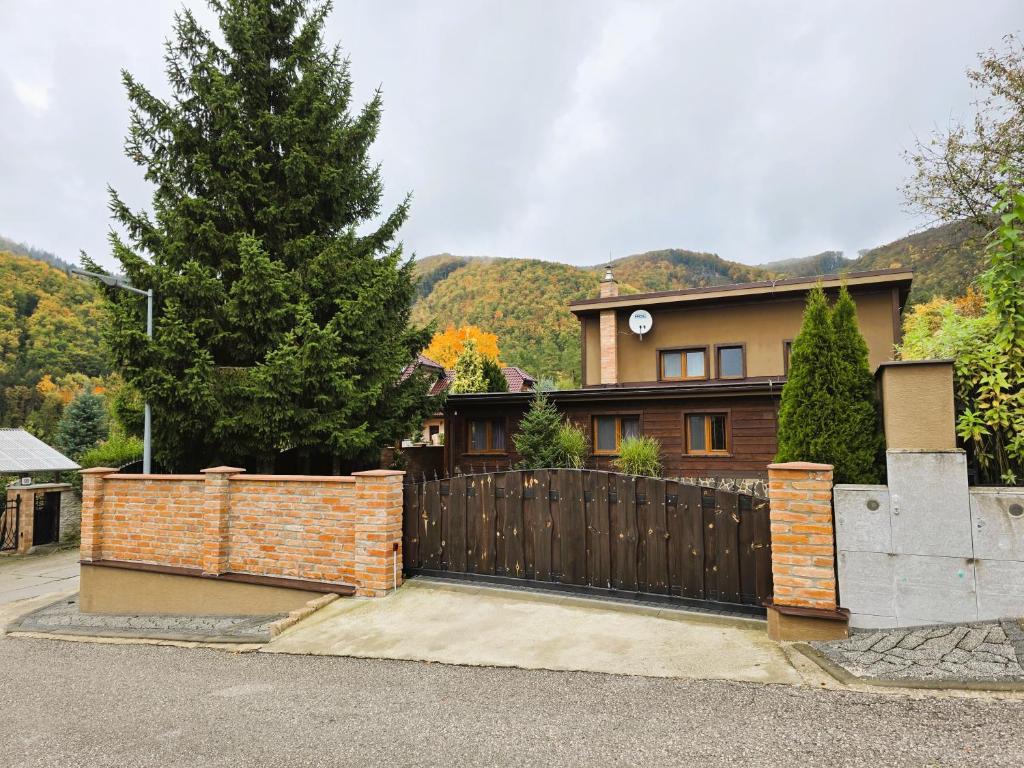 a house with a wooden gate and a fence at Villa Simona in Rajecké Teplice