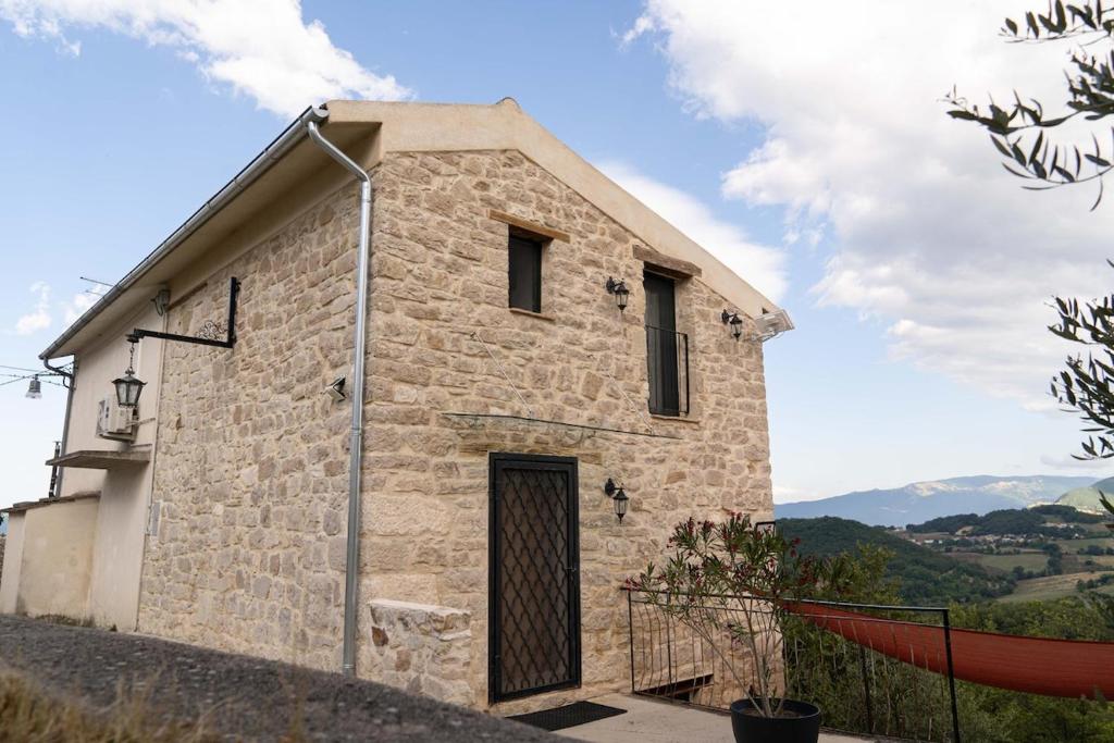a small stone building with a door on the side at Casa Rosa Tradizionale in Roccascalegna