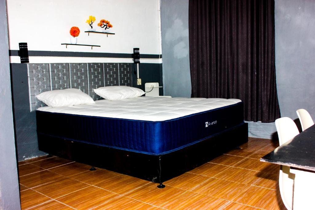 a large blue bed in a room with chairs at Penginapan The Guardians in Silangit International Airport