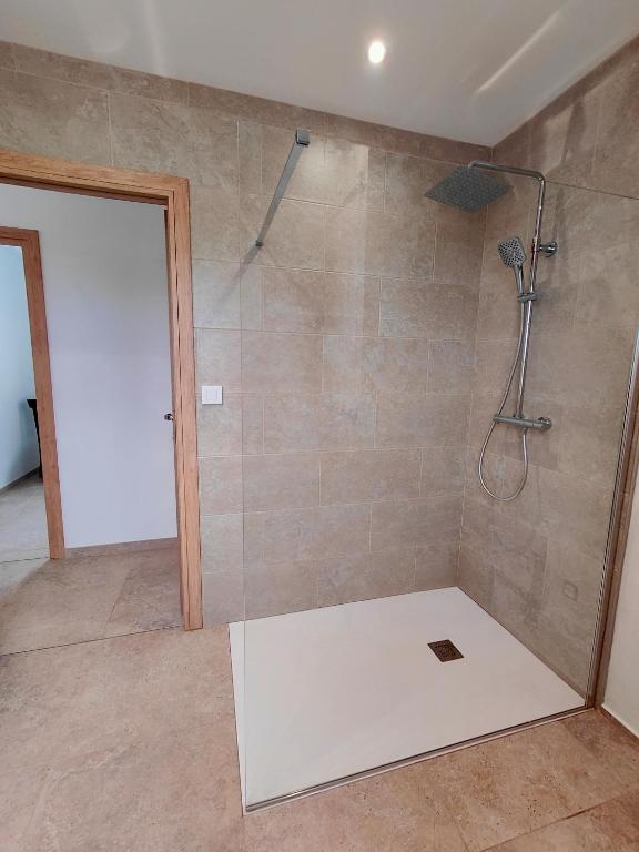 a shower with a glass door in a bathroom at Gite des Polders in Saint-Quentin-en-Tourmont