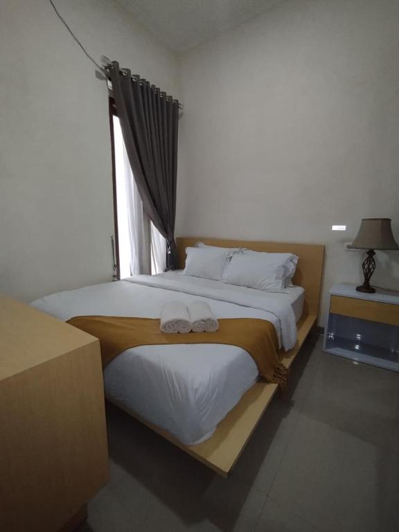 a bedroom with a bed with two towels on it at Mutu Edutel in Panggungrejo