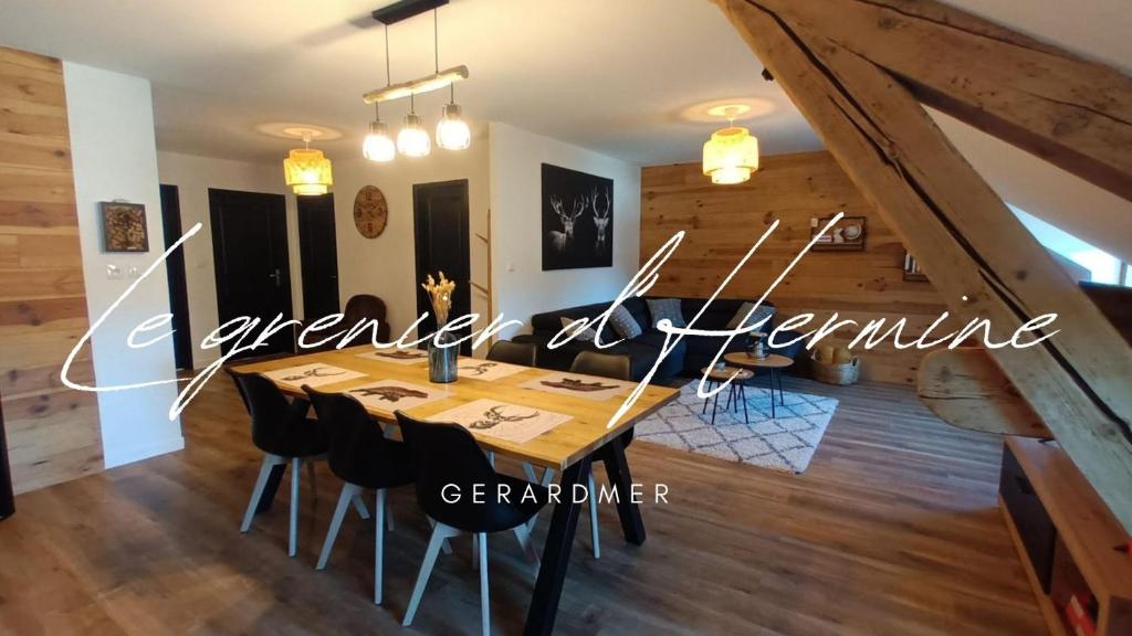 a dining room with a wooden table and chairs at Le grenier d Hermine in Gérardmer