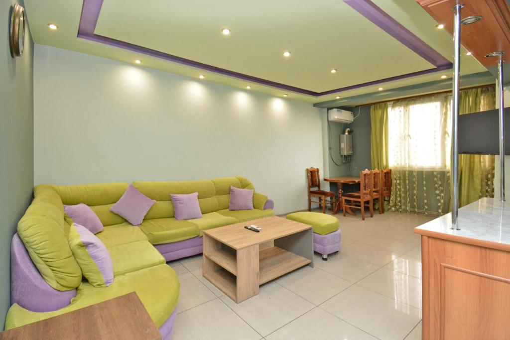 a living room with a green couch and a table at Loft Apartment in the heart of Yerevan in Yerevan