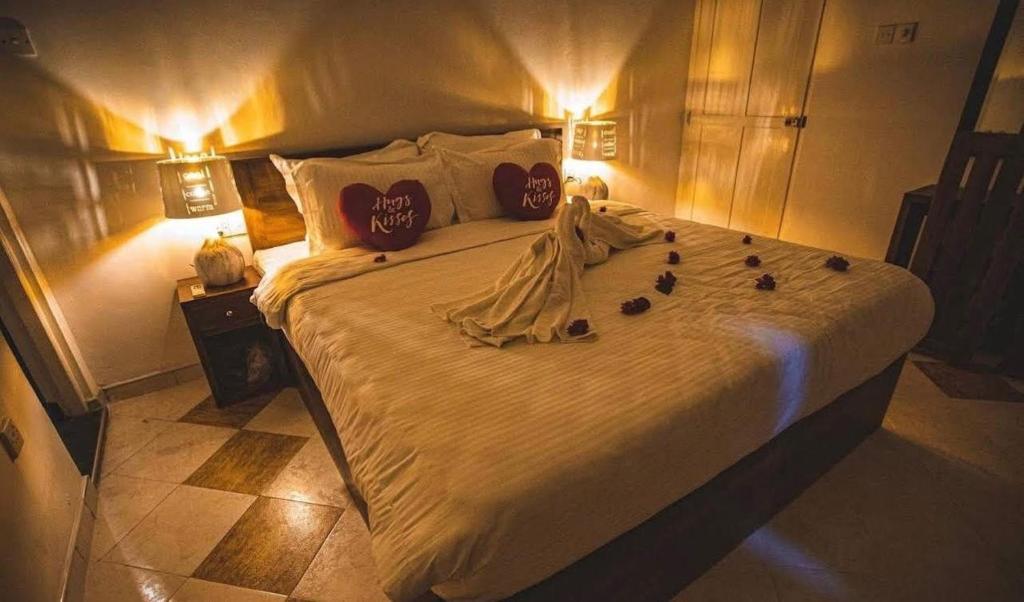 a bedroom with a large bed with some pillows at Riverview Bentota in Bentota