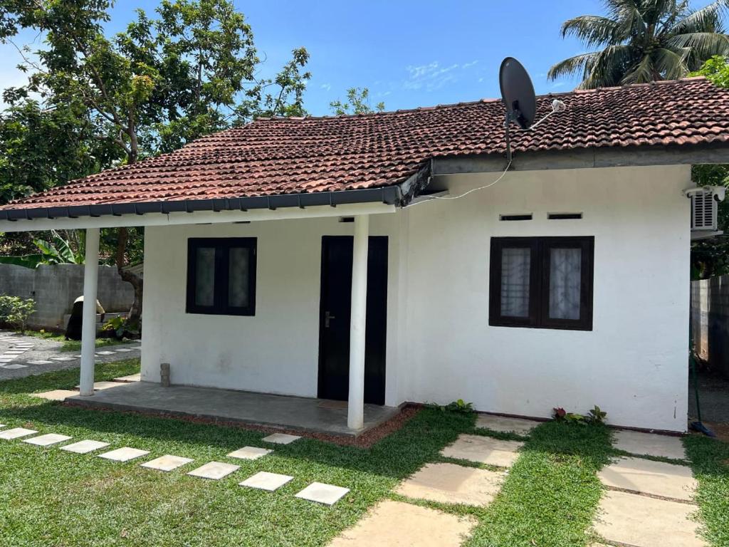 a small white house with a red roof at 7 S Villa & Cottage in Kamburugamuwa