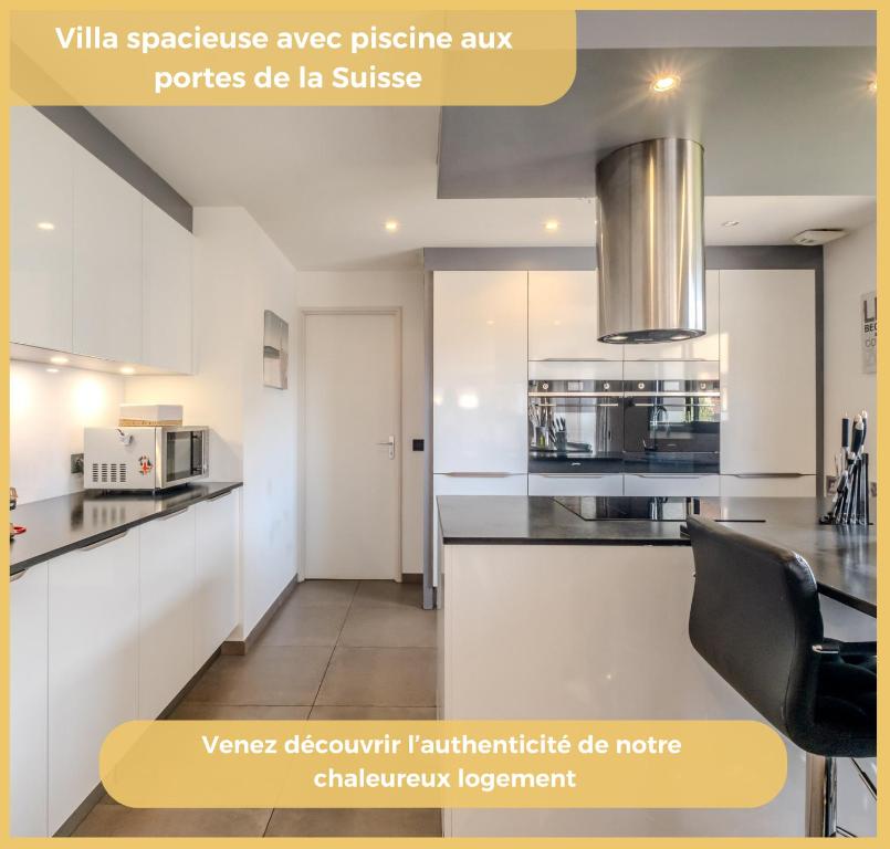 eine Küche mit weißen Schränken und schwarzen Arbeitsplatten in der Unterkunft Chez Inès I Villa aux portes de Genève in Feigères