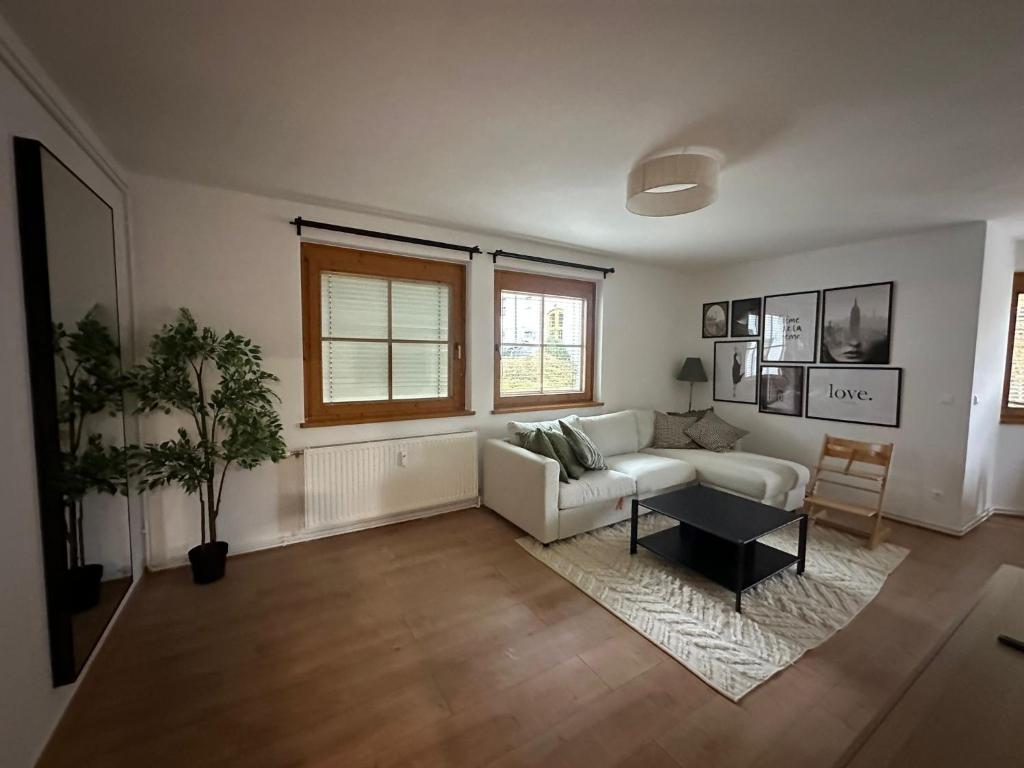 a living room with a white couch and a table at Alpine Oasis in Hermagor