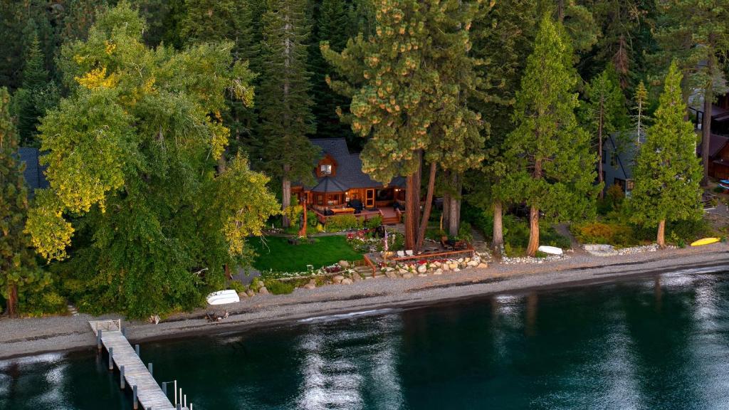 an aerial view of a house next to a body of water at Homewood Lakefront by AvantStay Private Beach Lake Access Views in Homewood
