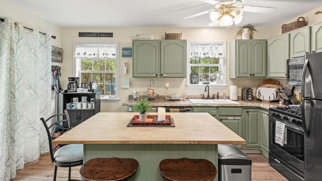 a kitchen with green cabinets and a wooden table at Ridge Retreat by AvantStay Game Room Covered Porch Fire Pit in Blakeslee