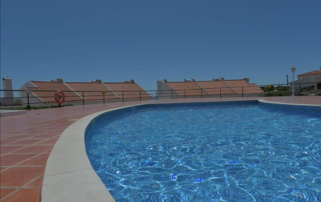 a large swimming pool on a building with chairs at Granny's House by Trip2Portugal in Carvoeira