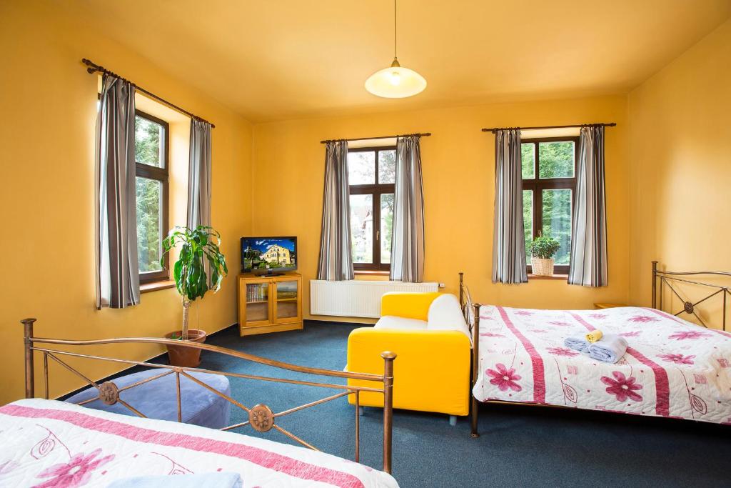 sypialnia z 2 łóżkami i żółtą ścianą w obiekcie Yellow Ski Apartments w Rokitnicach nad Izerą
