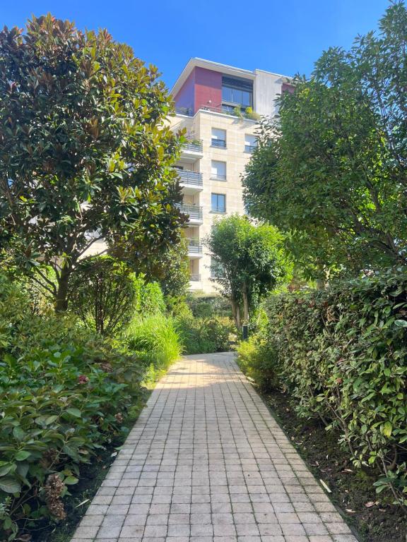 einen Backsteinweg vor einem Gebäude in der Unterkunft Appartement proche centre d'affaires calme et terrasse in Issy-les-Moulineaux
