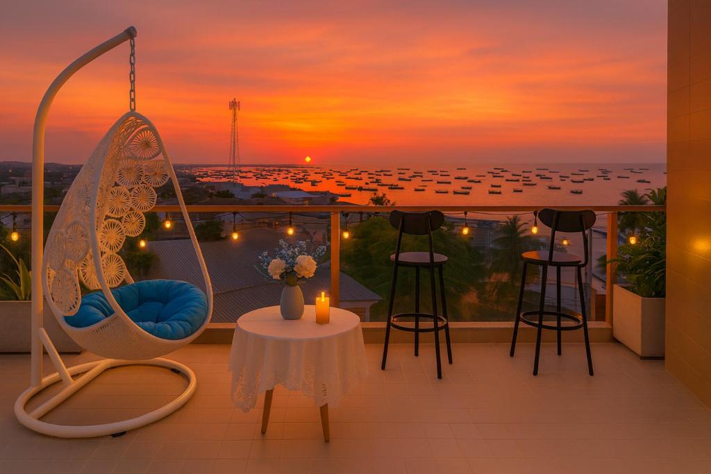 d'un balcon avec des chaises et des tables et un coucher de soleil. dans l'établissement Amory Sea View Pool Villa - 5 Bedrooms, à Mui Ne