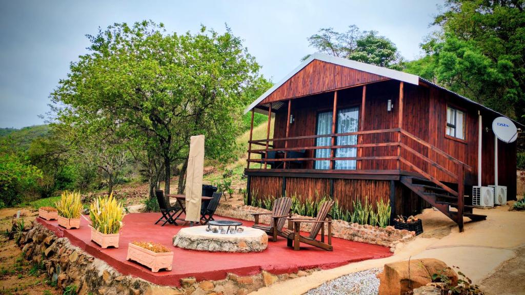 a small house with a red rug in front of it at Hill Top Cabin - Self Catering Accommodation in Hazyview