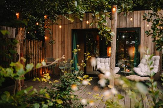 d'un jardin avec des chaises blanches et une clôture en bois. dans l'établissement Natuurhuisjes Westerwolde, à Bellingwolde