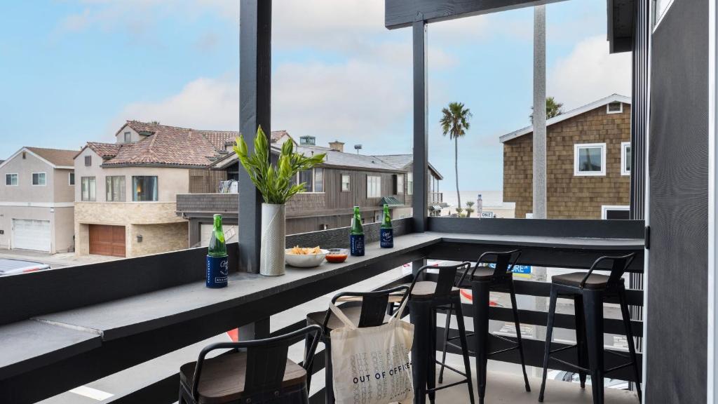 a balcony with a table and chairs and a window at Shelly by AvantStay Steps to the Beach Deck w Ocean Views 5BDR in Newport Beach