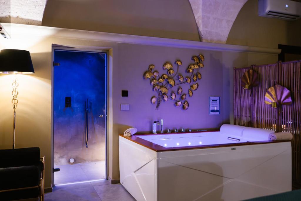 a purple bathroom with a tub and a sink at Siramà Suite Deluxe in Oria