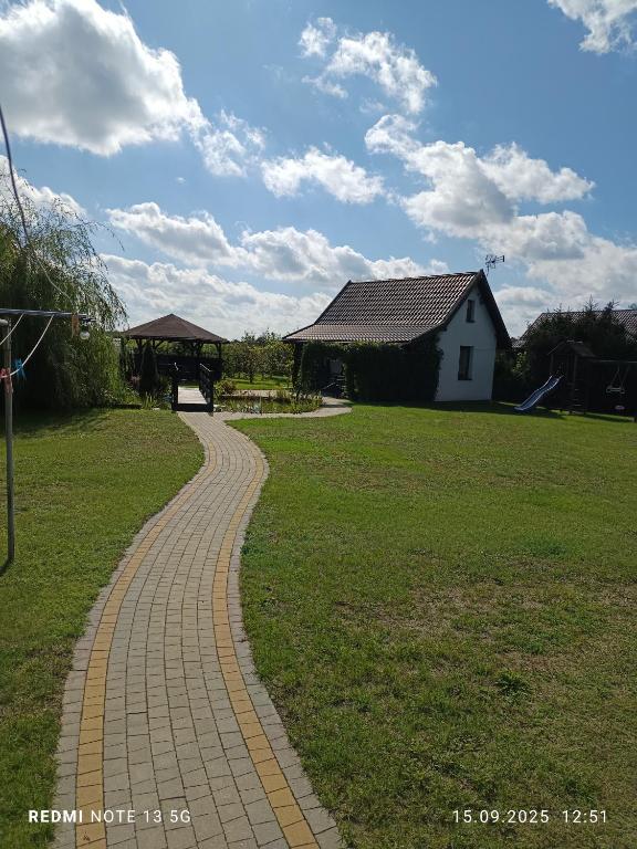 a brick path in front of a house and a building at Domek na Mazurach in Pisz