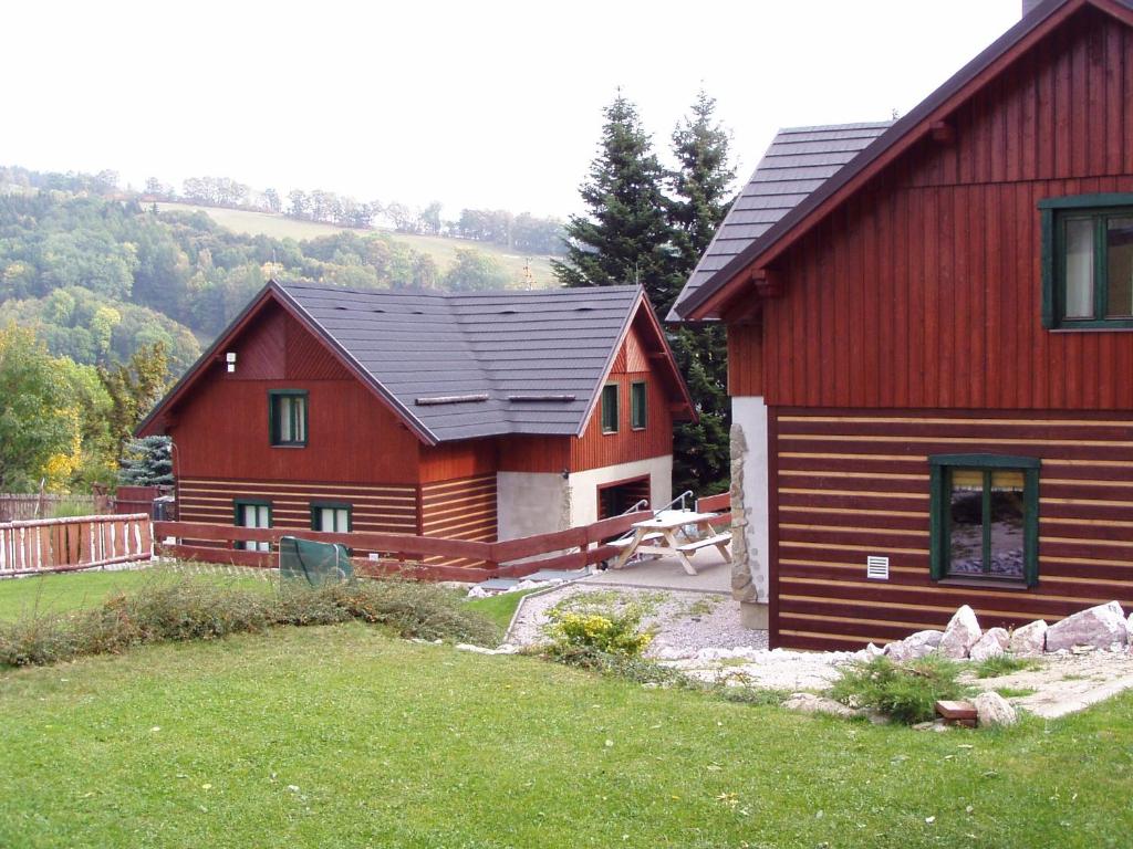 a large red house with a picnic table in front of it at Chaty Vrchlabí in Vrchlabí