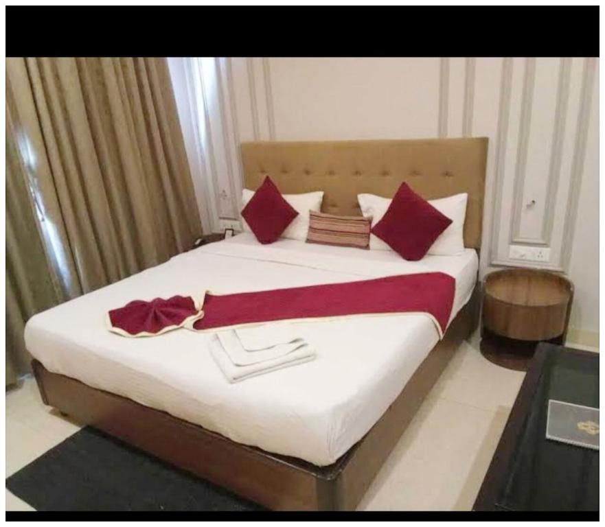 a bedroom with a large bed with red pillows at Hotel AV Ganges Varanasi - Walking Distance From BABA VISHWANATH TEMPLE #Wifi #Fully Air Conditioned & Spacious Rooms - Best Budget Hotel In Varanasi in Varanasi