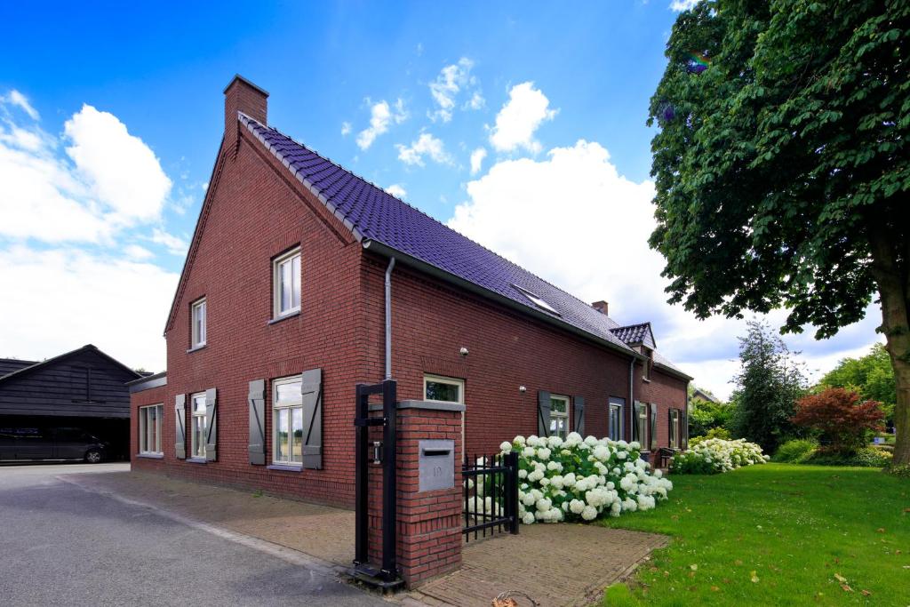 una casa de ladrillo rojo con una puerta delante de ella en Lokven Hoeve, en Vinkel