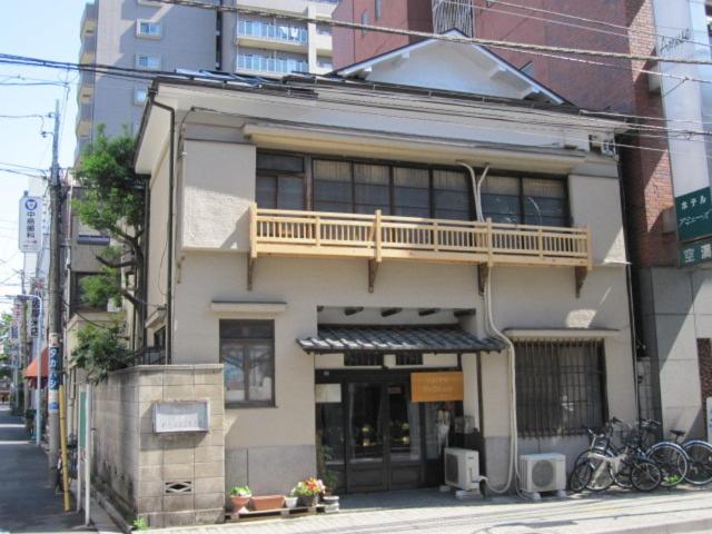 a building with a balcony on top of it at Taito Ryokan in Tokyo