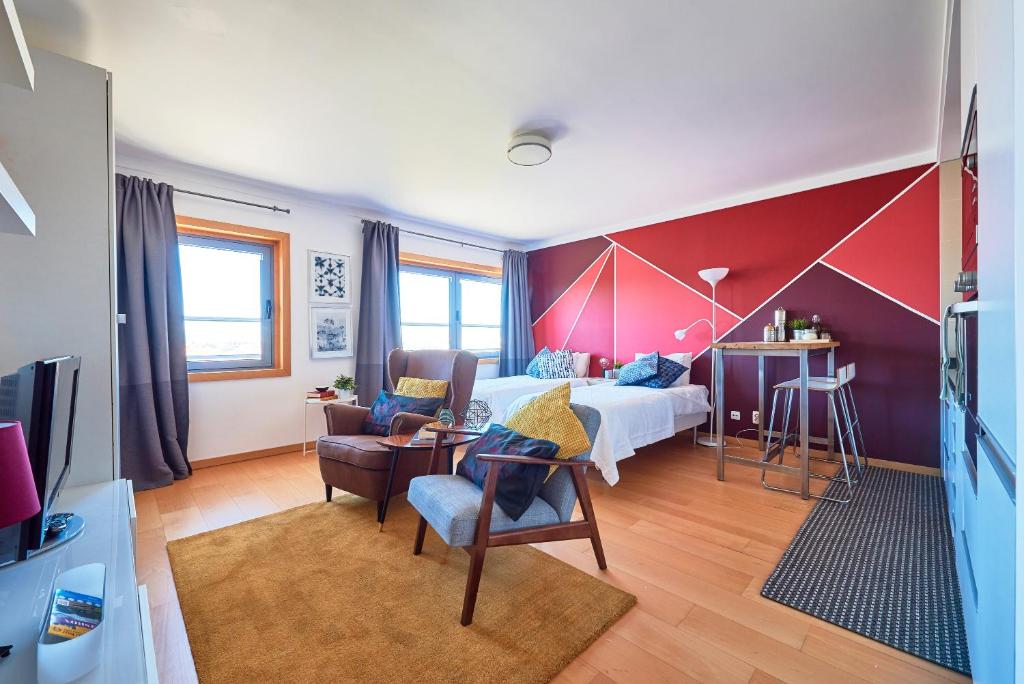 a bedroom with a bed and a red wall at Expo Studio in Lisbon
