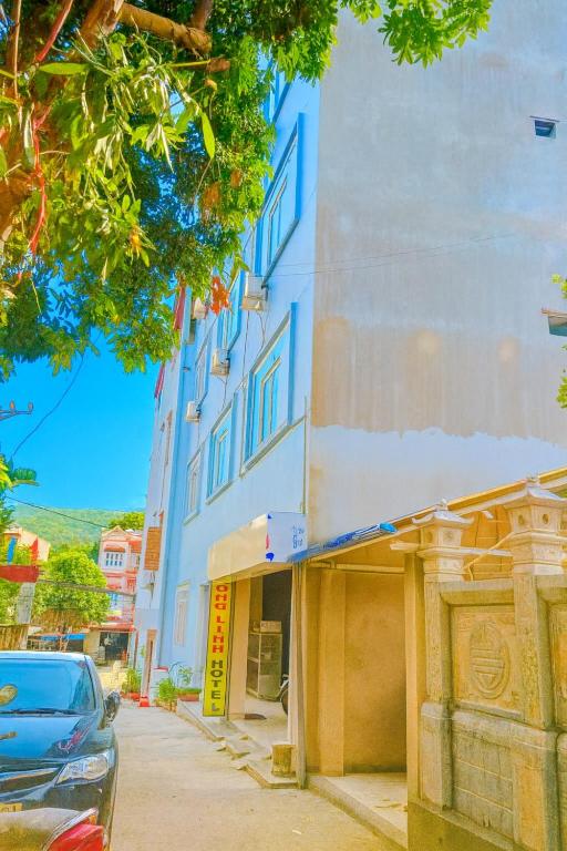 a blue building with a car parked in front of it at Phuong Linh Hotel in Bảo Lạc