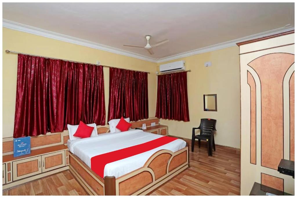 1 dormitorio con 1 cama grande y cortinas rojas en HOTEL PINK-Villa Near Budha Jayanti Park- with free wifi - Restaurant Facilities Available - Best Hotel In Bhubneshwar, en Cuttack