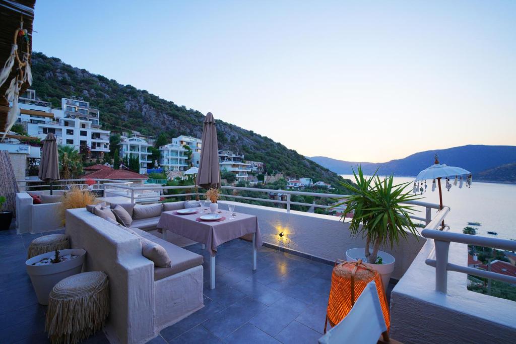 a balcony with a couch and tables and a view of the water at Kalkan Ayapa Hotel in Kaş