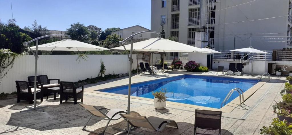 una piscina con sillas, mesas y sombrillas en Pantanha Studio by Trip2Portugal, en Canas de Senhorim