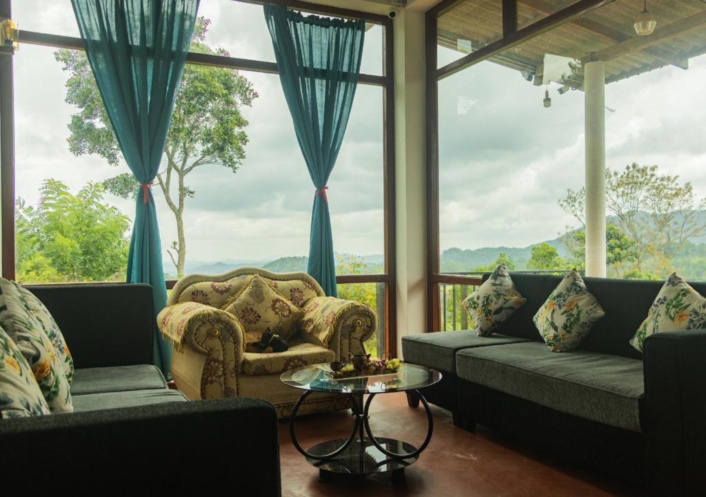 a living room with couches and a table at Knight's Dale Knuckles Holiday Bungalow in Kandy