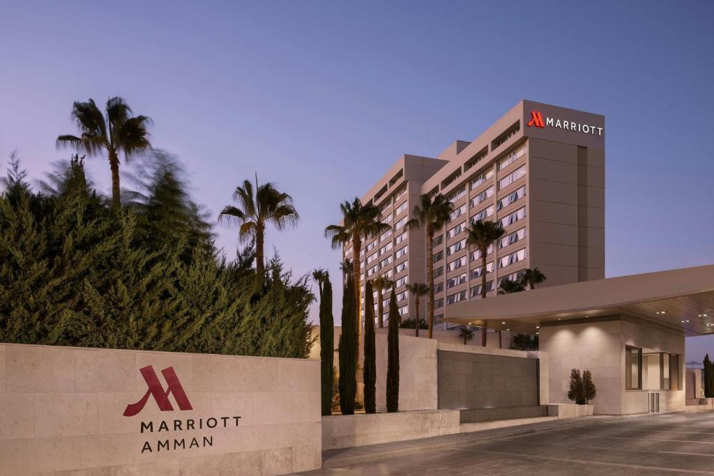 a hotel with palm trees in front of a building at Amman Marriott Hotel in Amman
