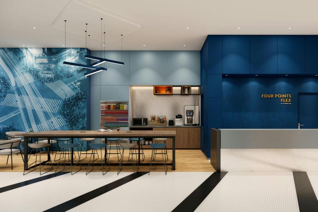 東京にあるフォーポイント フレックス by シェラトン 東京渋谷ウエストのテーブルと椅子のあるキッチンとダイニングルーム